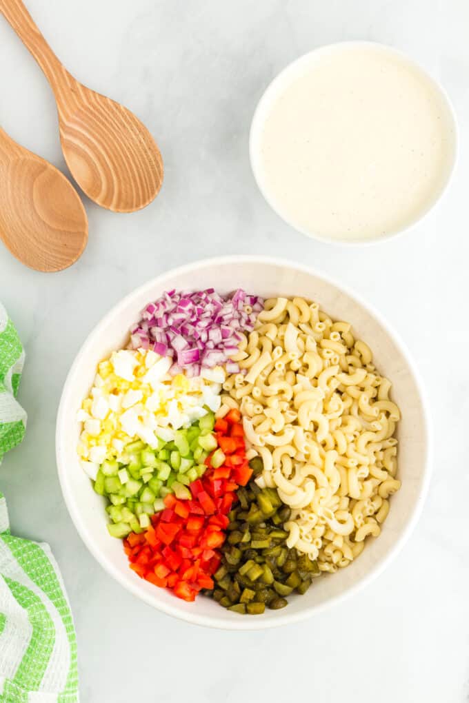 mixing bowl with ingredients to make macaroni salad