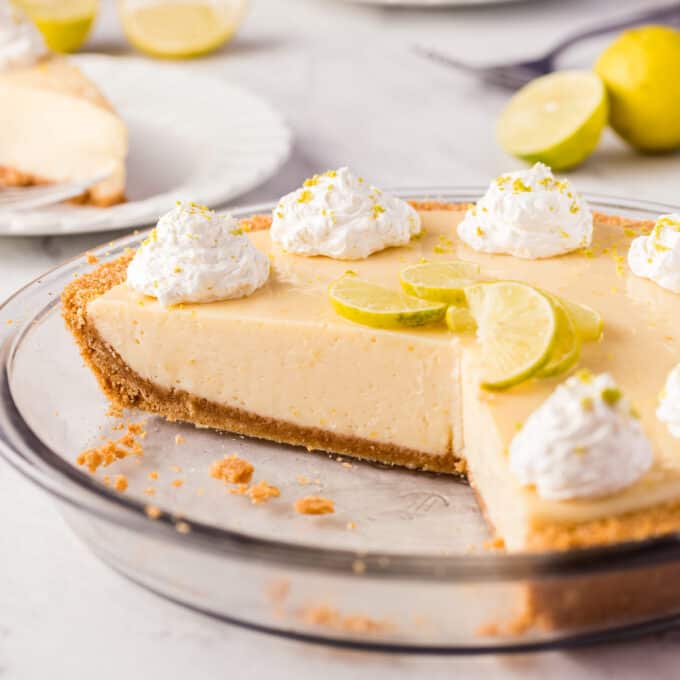 key lime pie in glass pie pan with a few slices taken out.