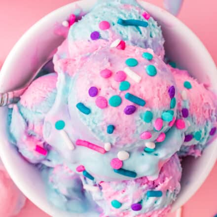 white bowl filled with multiple scoops of cotton candy ice cream.