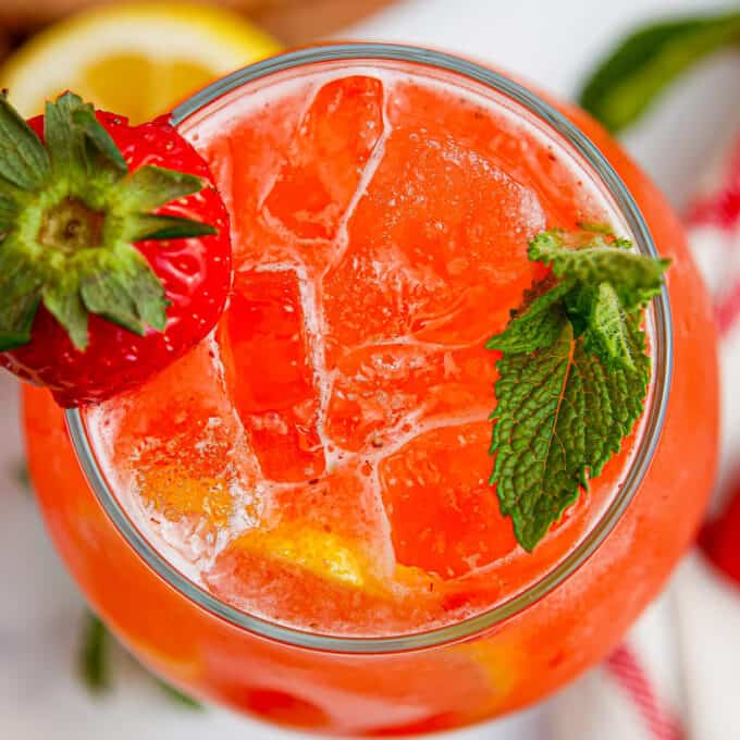 overhead photo of a glass of strawberry lemonade garnished with mint and strawberry.