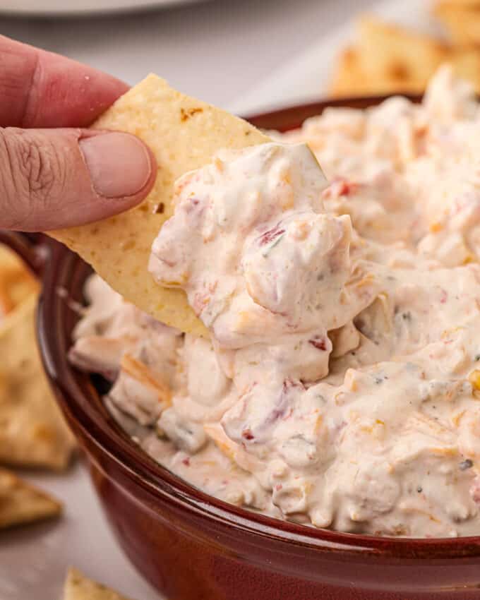 dipping a tortilla chip into a bowl of rotel ranch dip.