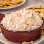 brown serving bowl of creamy rotel ranch dip with chips for dipping.