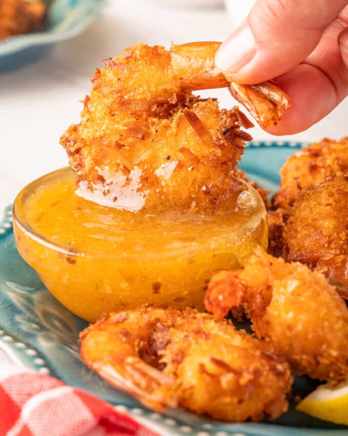 dipping a coconut crusted shrimp into a dijon marmalade sauce.