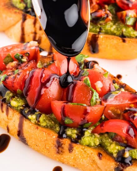 Crisp golden brown baguette slices are topped with a flavorful basil pesto, then a simple tomato bruschetta topping and drizzled with a sweet and tangy balsamic glaze. This is the ultimate summer appetizer, and sure to be a true crowd-pleaser!