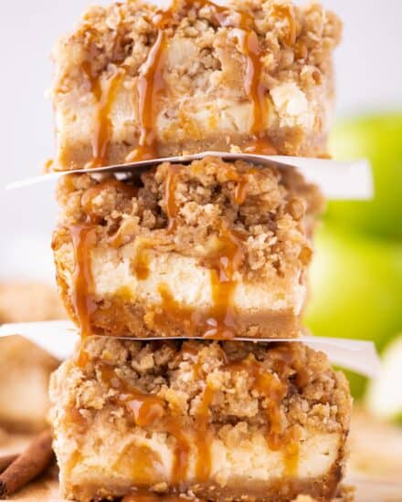 These cheesecake bars are made with an easy shortbread cookie crust, classic creamy cheesecake filling, cinnamon spiced apple pieces, and topped with a sweet crumble topping and decadent drizzle of caramel sauce!  Made easily in a regular baking dish, and with NO water bath, these bars take the difficulty out of making cheesecake!