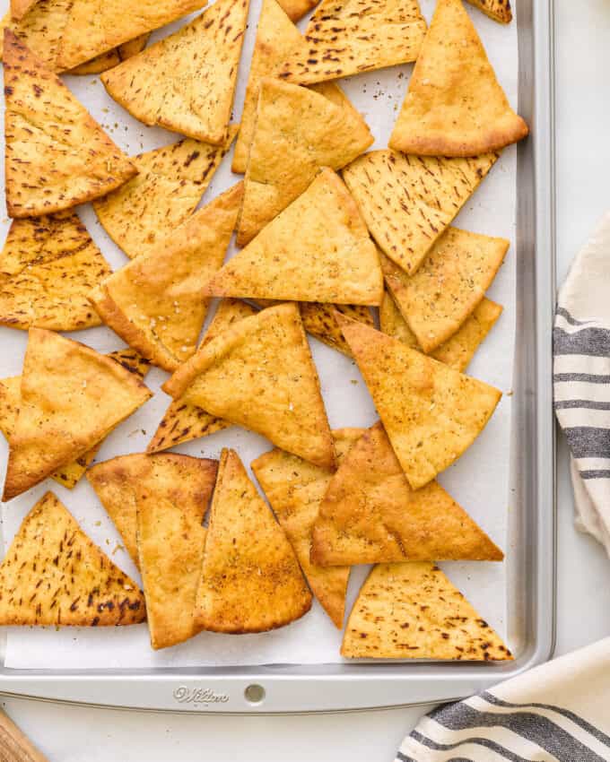 overhead photo of baked pita chips on a baking sheet.