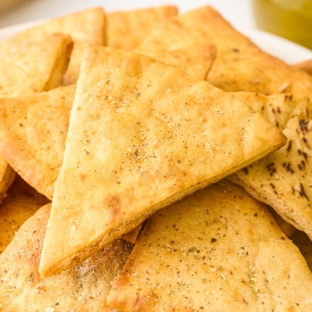 pile of baked pita chips in a white bowl.