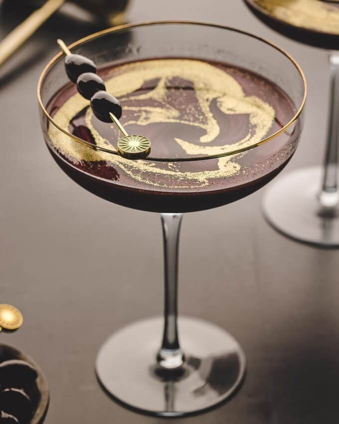 black magic martini recipe in a glass, showing what the drink looks like without the luster dust swirled in.