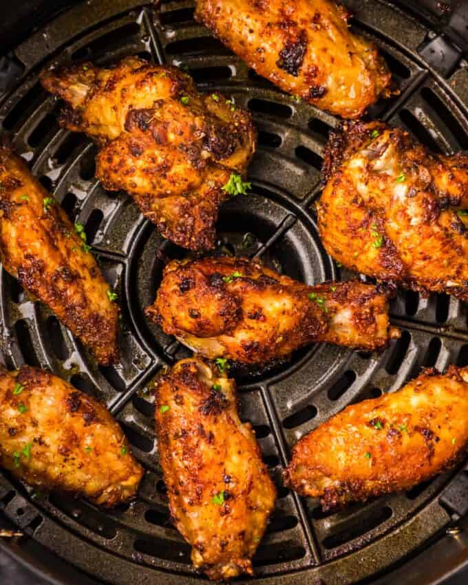 dry rubbed chicken wings cooked in a black air fryer basket.