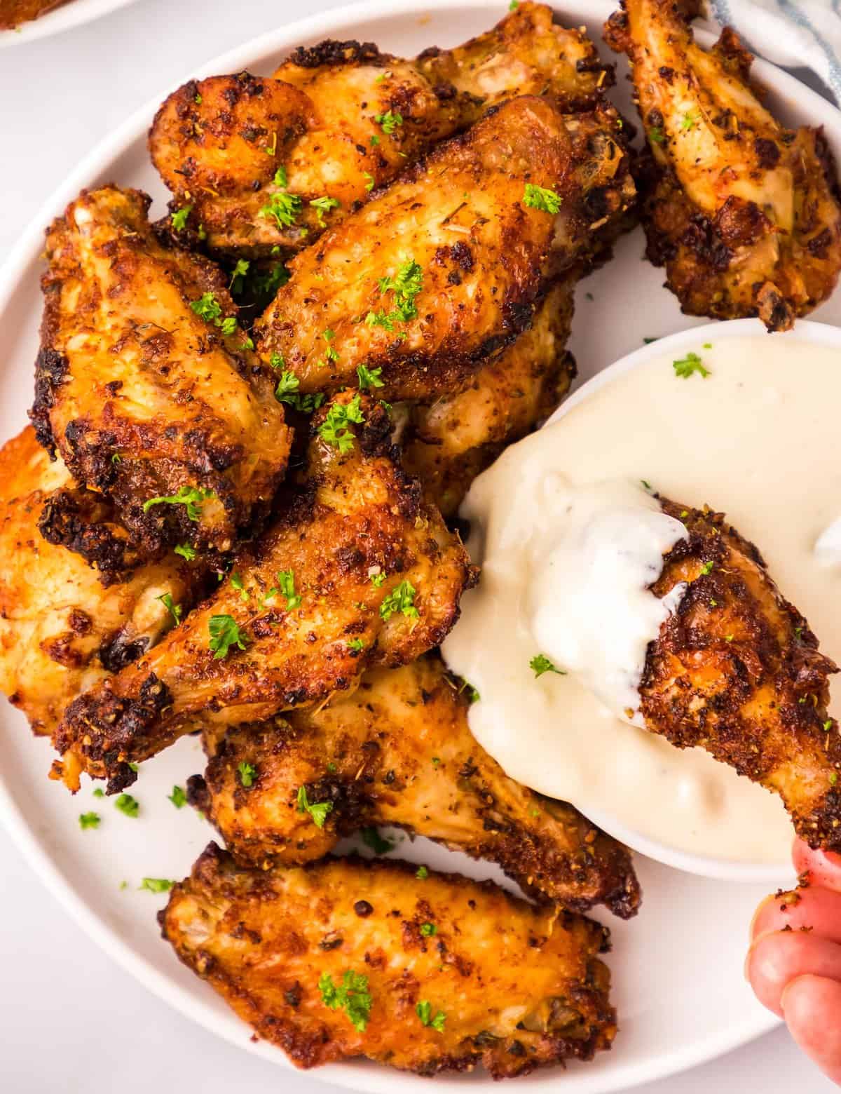 The best chicken wings are tender, juicy, and perfectly crispy! That's exactly what you get when you cook wings in an air fryer. This recipe uses a simple dry rub to add bold flavors, and a cooking method that yields some of the best wings you'll have!