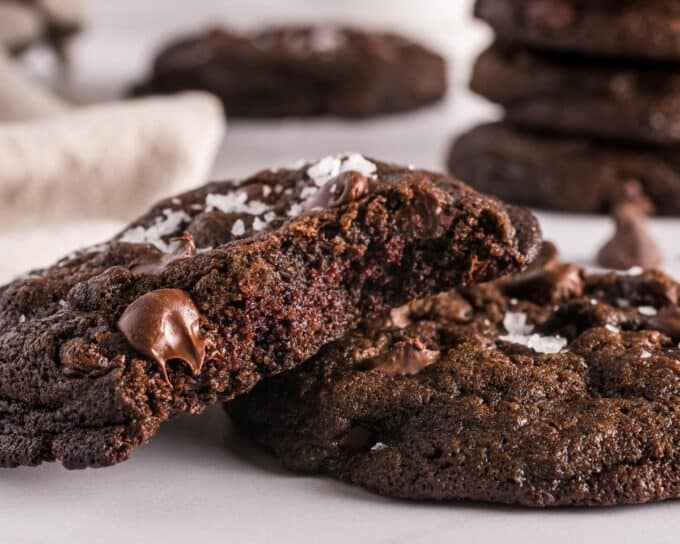 Photo showing a double chocolate chip cookie that's broken in half.