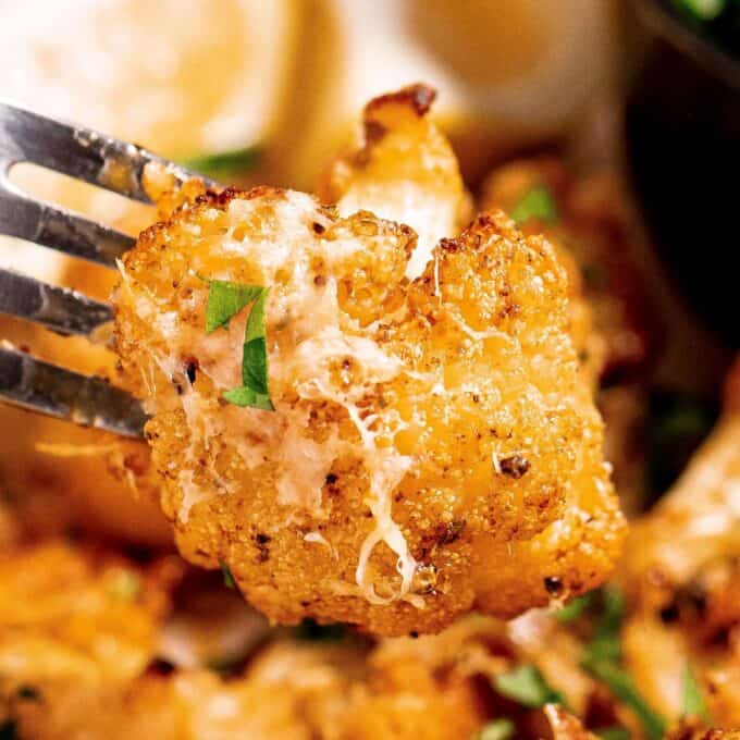close up photo of a piece of roasted cauliflower on a fork.