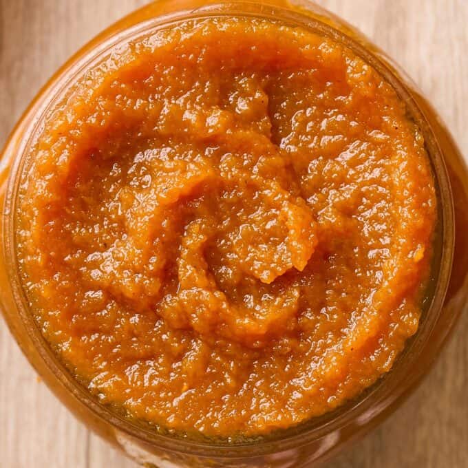 overhead photo of a glass jar filled with spiced pumpkin butter.