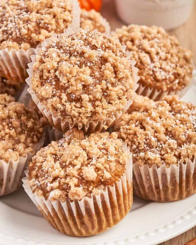 pile of pumpkin streusel muffins on white plate.