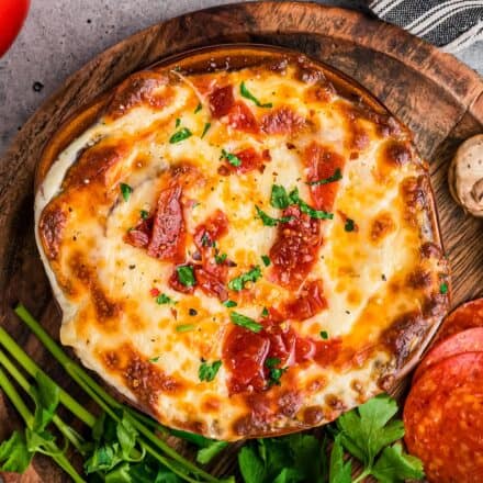 overhead photo of a crock full of pizza soup with a cheesy crust on top.