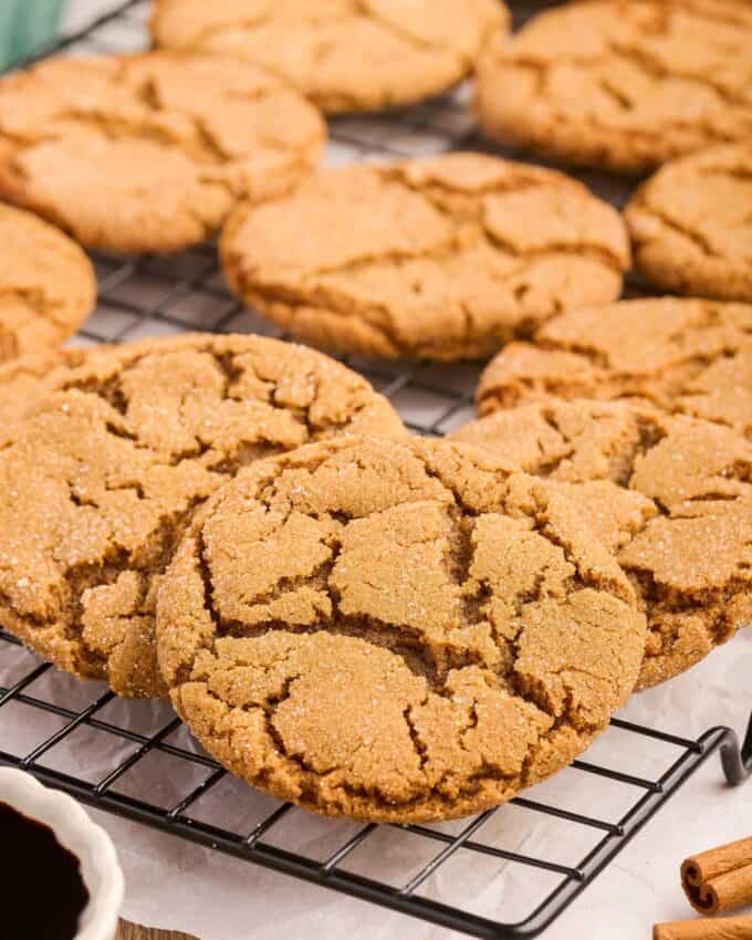 molasses cookies on a black cooling rack.