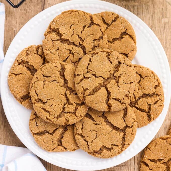 pile of molasses cookies on a white plate.