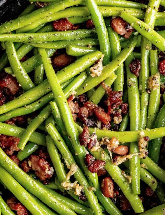 Simple and easy, these garlic green beans with bacon and Parmesan cheese are made using fresh green beans that are cooked until crisp tender, and seasoned with bold flavors! Theyโre the perfect side dish that even the kids will love!