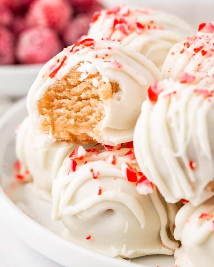 pile of candy cane cake balls, with a bite taken out of one of them.