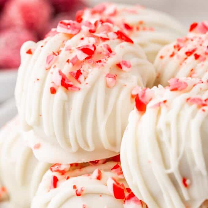 close up photo of a white chocolate drizzled peppermint cake ball.