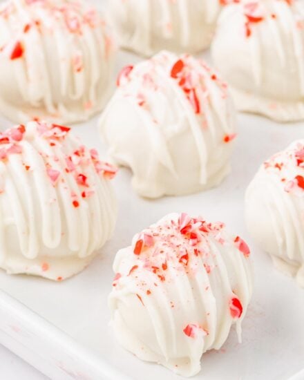 These candy cane cake balls are full of sweet peppermint flavor and crunch, coated in a vanilla candy coating, and sprinkled with more crushed candy canes! Perfect for the holidays, these are just like cake pops (just without the stick), and a favorite among people of all ages!