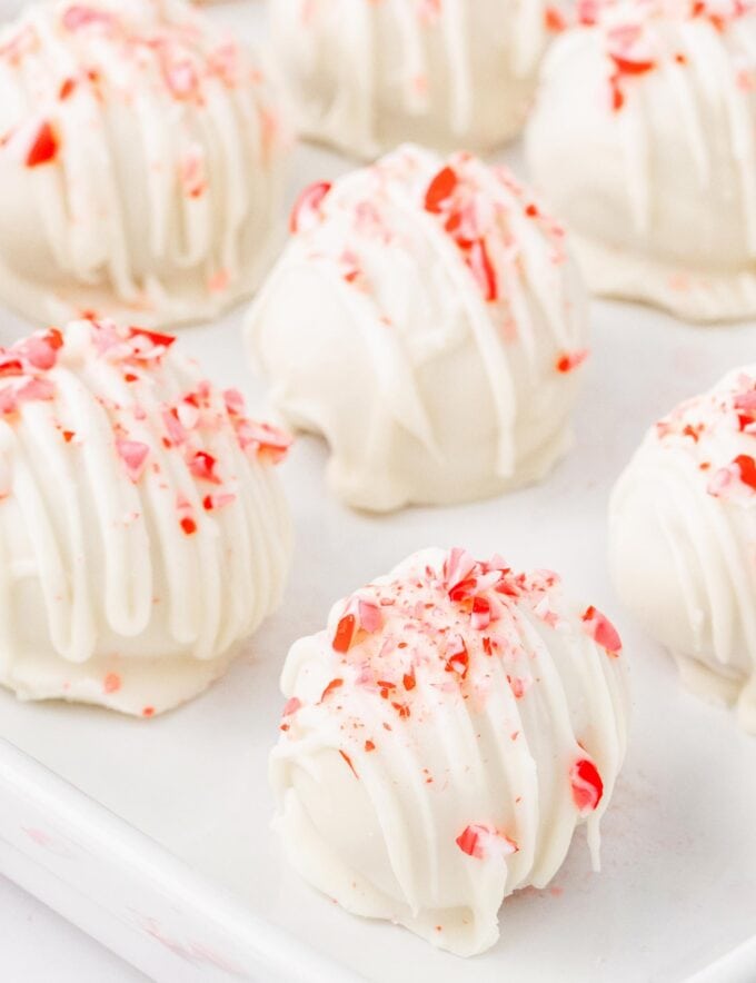 These candy cane cake balls are full of sweet peppermint flavor and crunch, coated in a vanilla candy coating, and sprinkled with more crushed candy canes! Perfect for the holidays, these are just like cake pops (just without the stick), and a favorite among people of all ages!