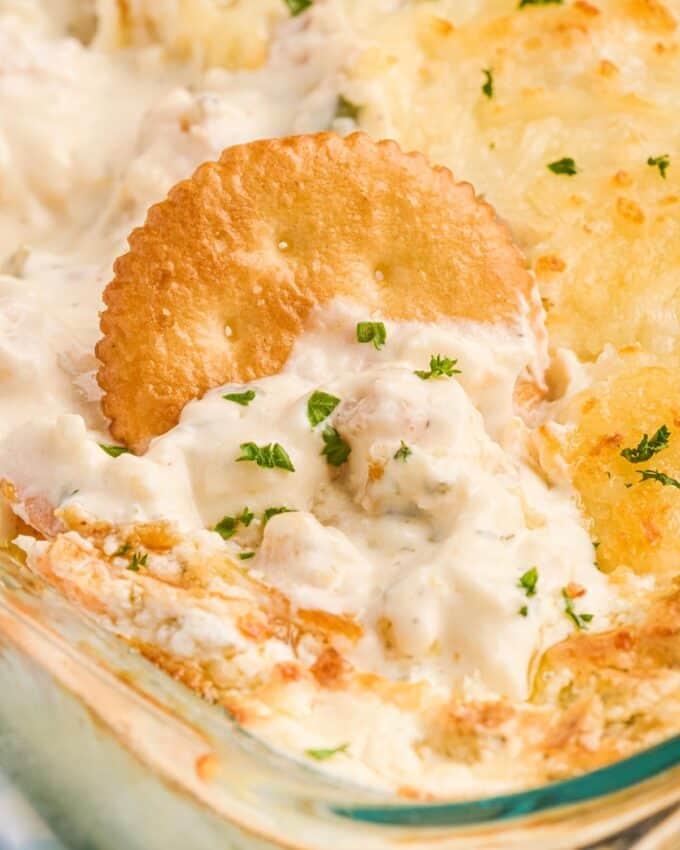 ritz cracker dipped into shrimp scampi dip.