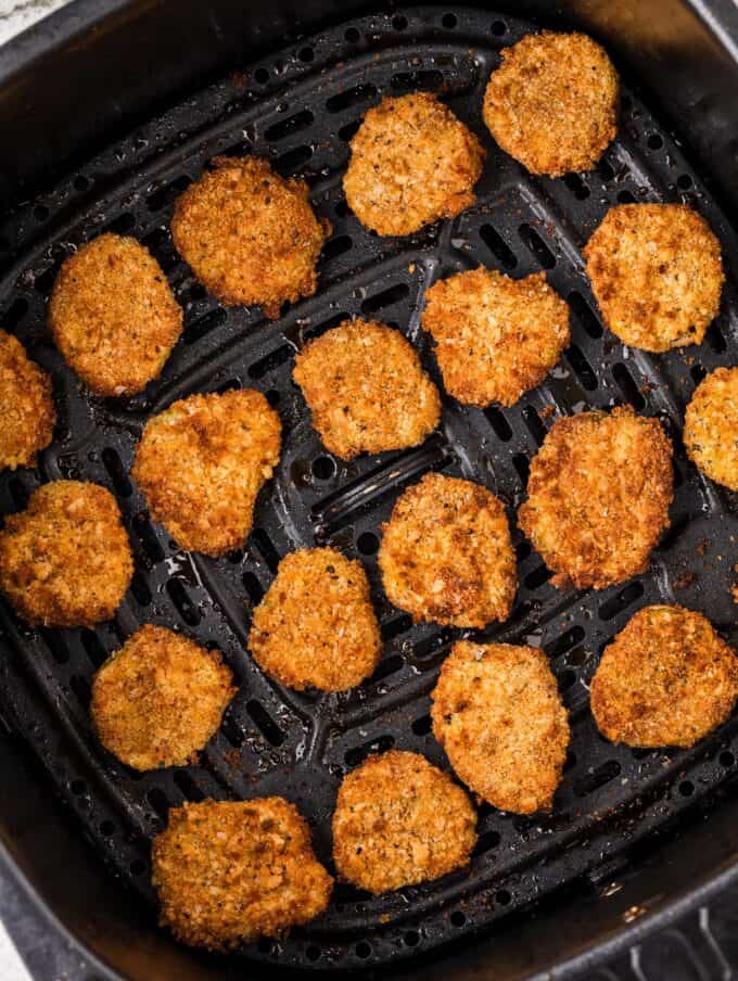 fried pickles in the basket of an air fryer