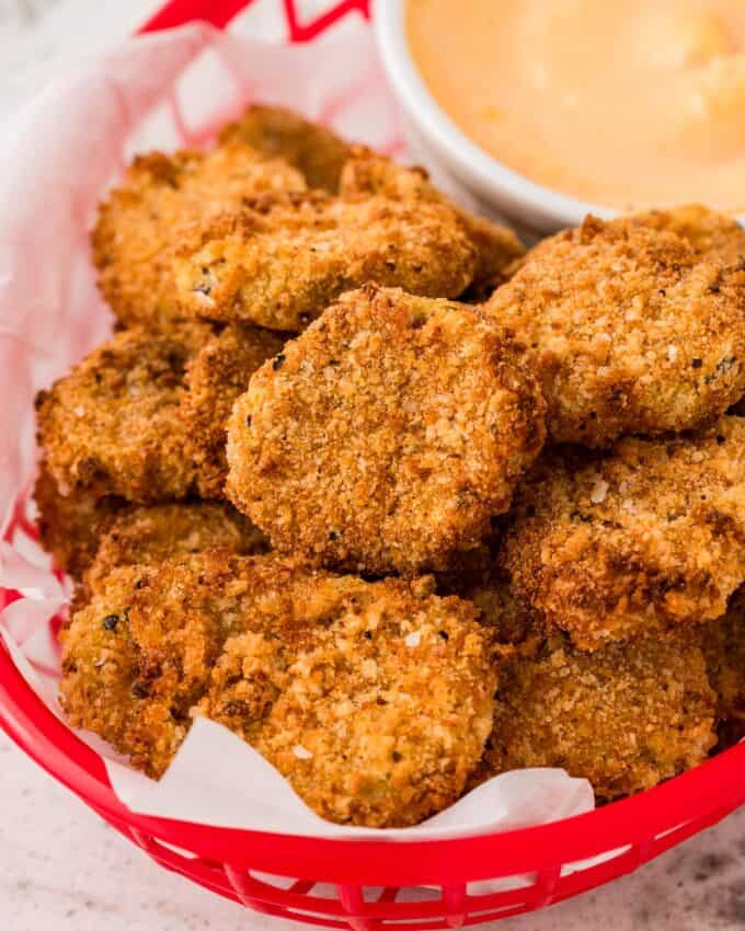 basket filled with fried pickles and a dipping sauce.