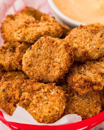 These "fried" pickles are the ultimate party food! Made with simple ingredients like dill pickles, flour, eggs, seasonings and breadcrumbs, this appetizer recipe is made easily in the air fryer (oven directions too)!