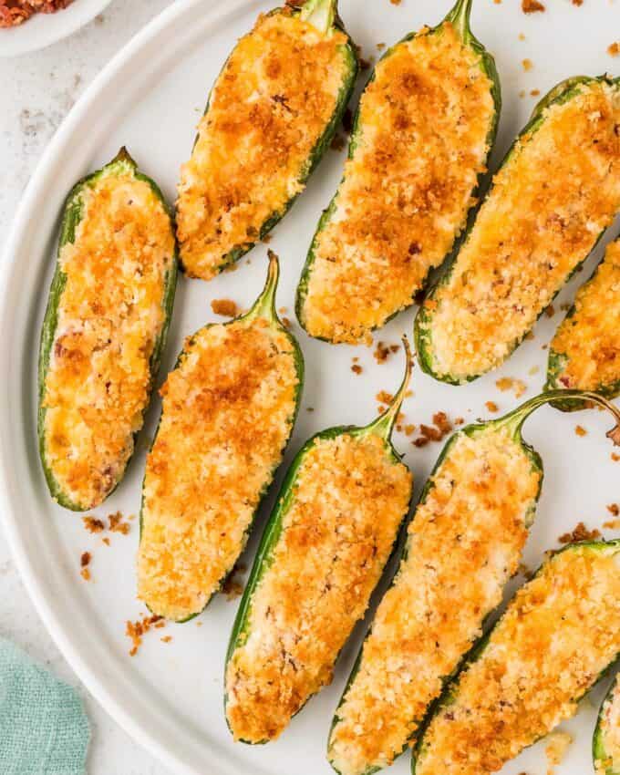 white plate full of jalapeño poppers topped with panko breadcrumbs.