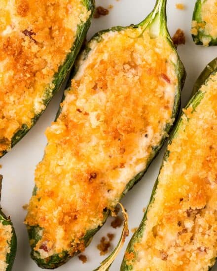 These jalapeño poppers are the ultimate party food! Made with fresh peppers, a rich and creamy cheesy filling, crispy bacon bits, and a crunchy panko breadcrumb topping... this appetizer recipe is made easily in the air fryer (oven directions too)!