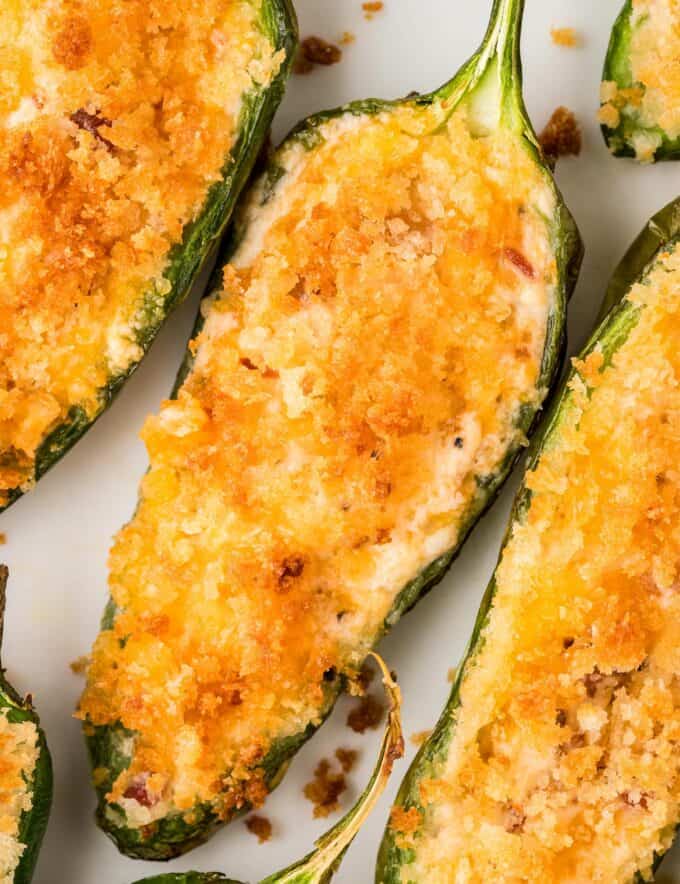 These jalapeño poppers are the ultimate party food! Made with fresh peppers, a rich and creamy cheesy filling, crispy bacon bits, and a crunchy panko breadcrumb topping... this appetizer recipe is made easily in the air fryer (oven directions too)!