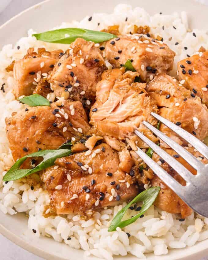 fork flaking a piece of ginger sesame salmon.