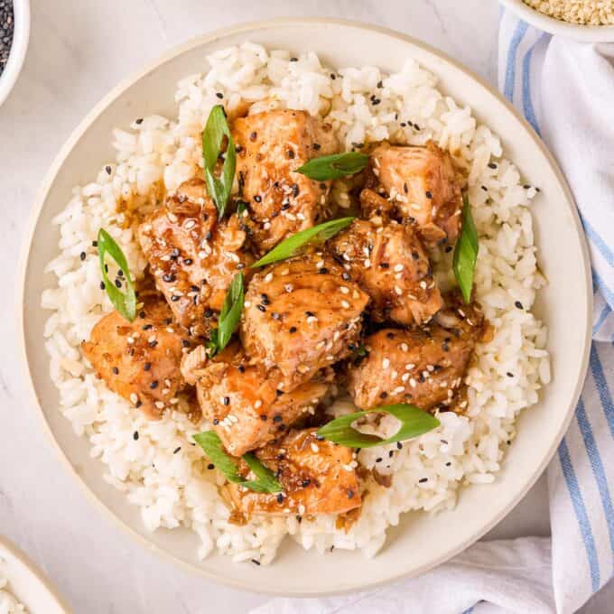 ginger salmon bites piled on a bed of white rice.