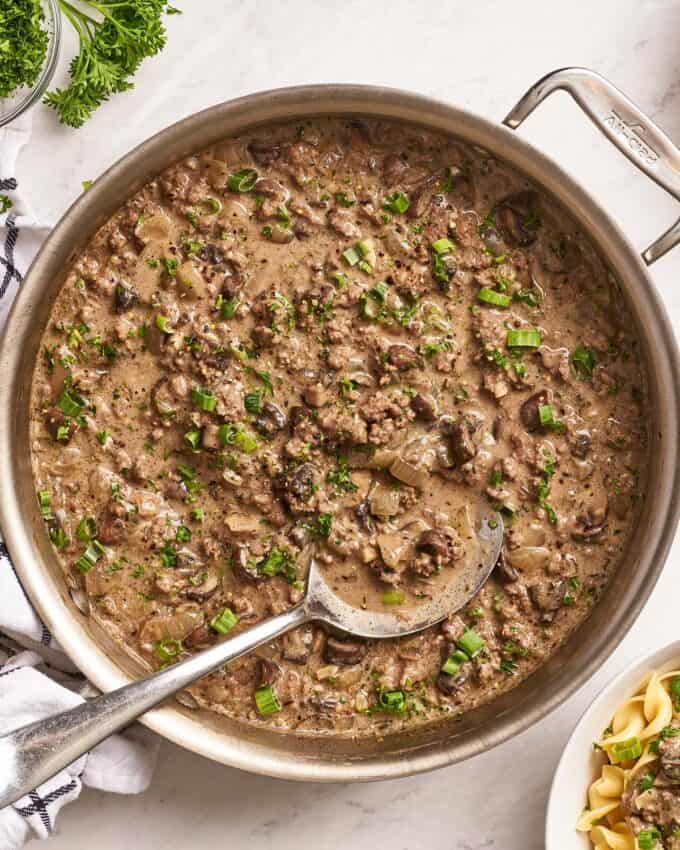 beef stroganoff gravy in a skillet with a serving spoon.