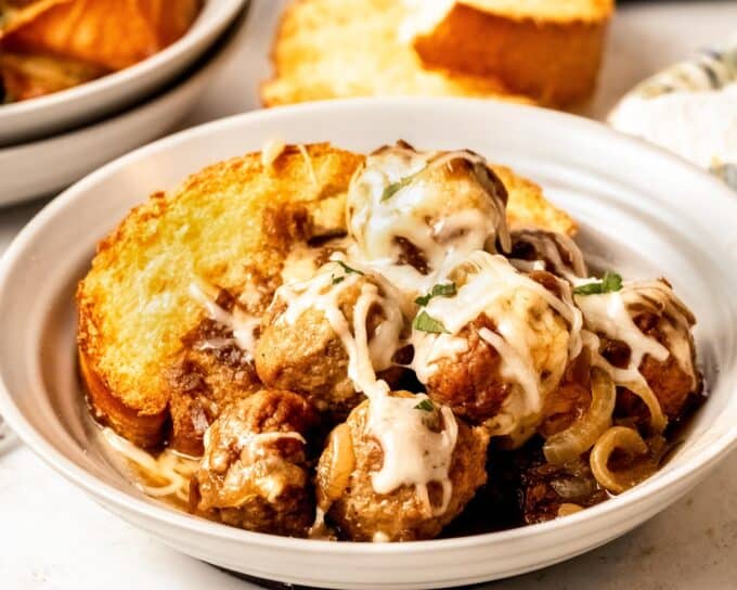 bowl filled with toasted french bread and french onion meatballs.