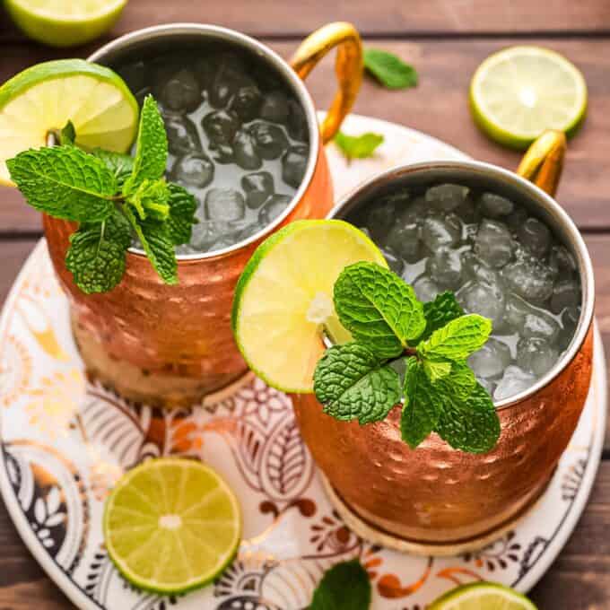 two mugs of moscow mule on a serving platter.