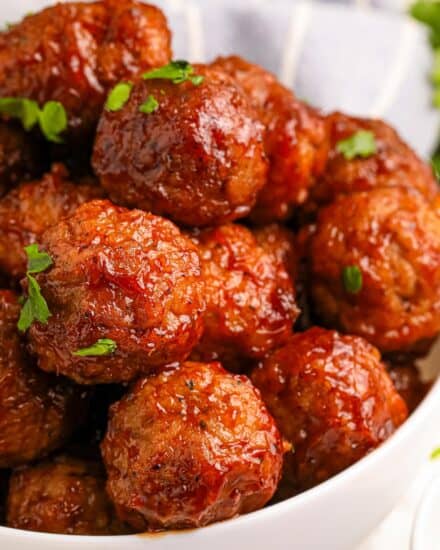 These Raspberry Balsamic Crockpot Meatballs are made easily with frozen meatballs and cooked low and slow in a mouthwatering sweet and savory sauce made from just 5 ingredients! Perfect as a party appetizer, game day treat, or fun dinner!