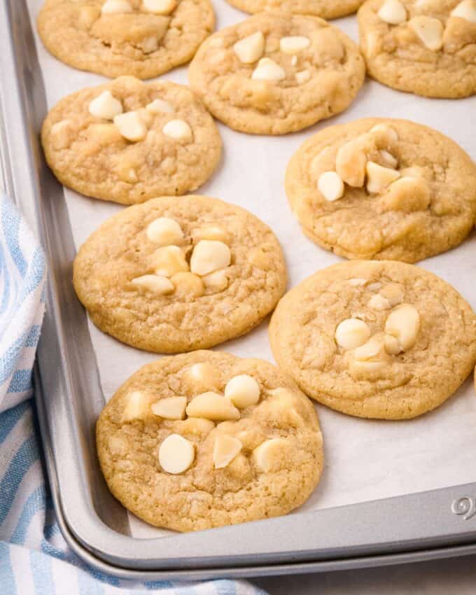 white chocolate macadamia nut cookies on baking sheet with parchment paper.