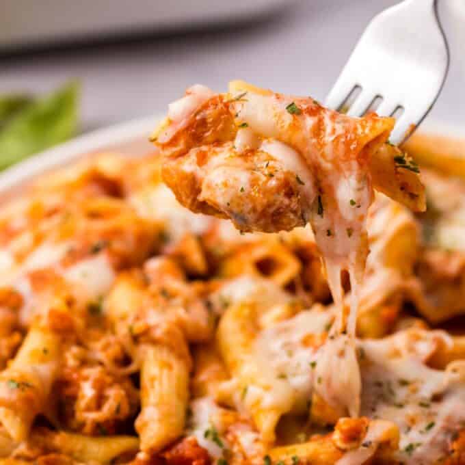 forkful of chicken parmesan casserole with gooey cheese.