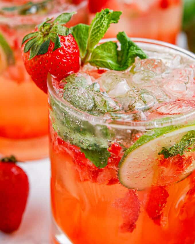 side view of strawberry mojito garnished with mint and a strawberry.