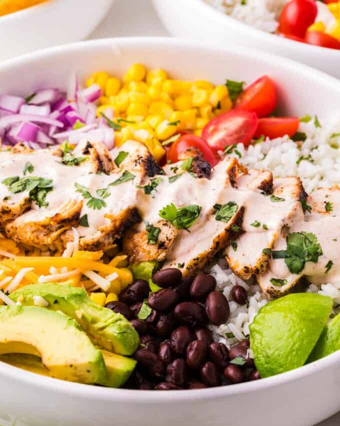 chicken burrito bowl with crema drizzled over the top.