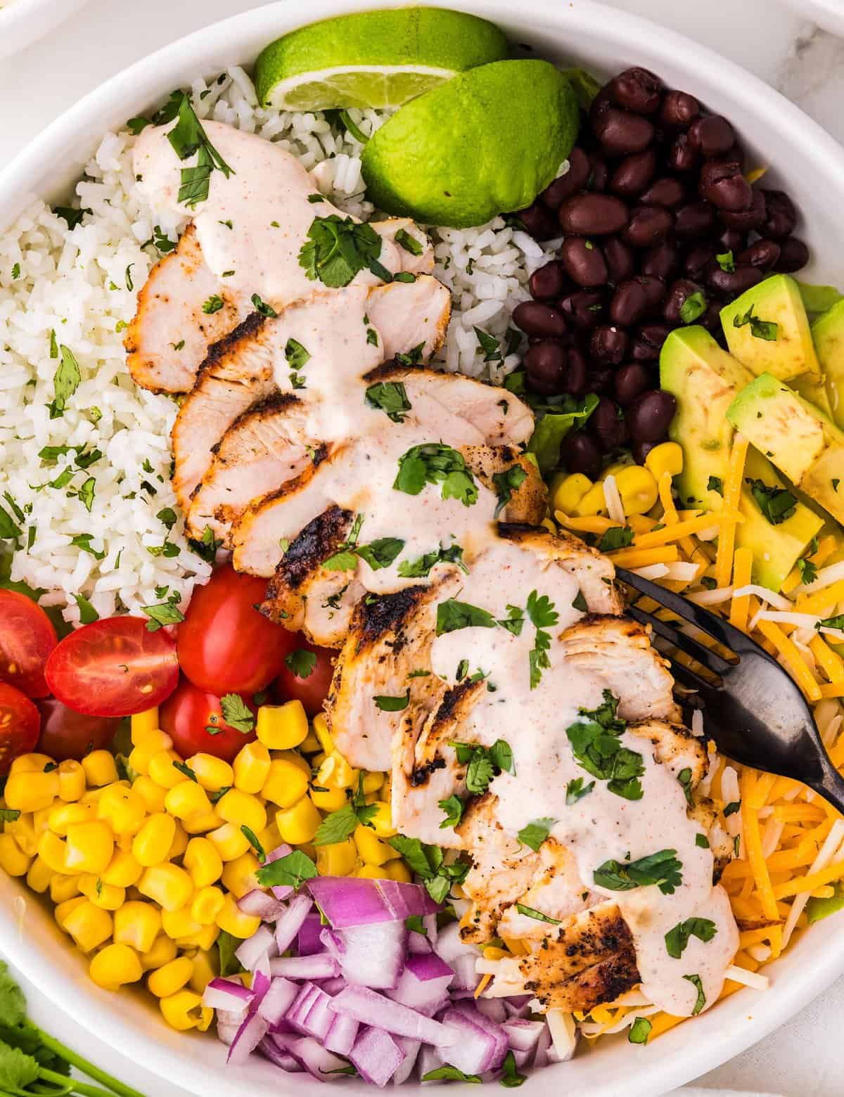 These chicken burrito bowls are a fun family dinner that can be made using a lot of leftovers, and parts of the recipe can be made ahead of time. This tex-mex recipe is also great for meal prep, and easy to customize to your tastes!