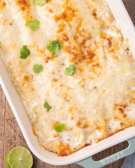These creamy white chicken enchiladas are made with shredded chicken, smoky salsa verde, piled high with cheese, and smothered in a mouthwatering homemade spicy and creamy sauce, and baked to gooey cheesy perfection!
