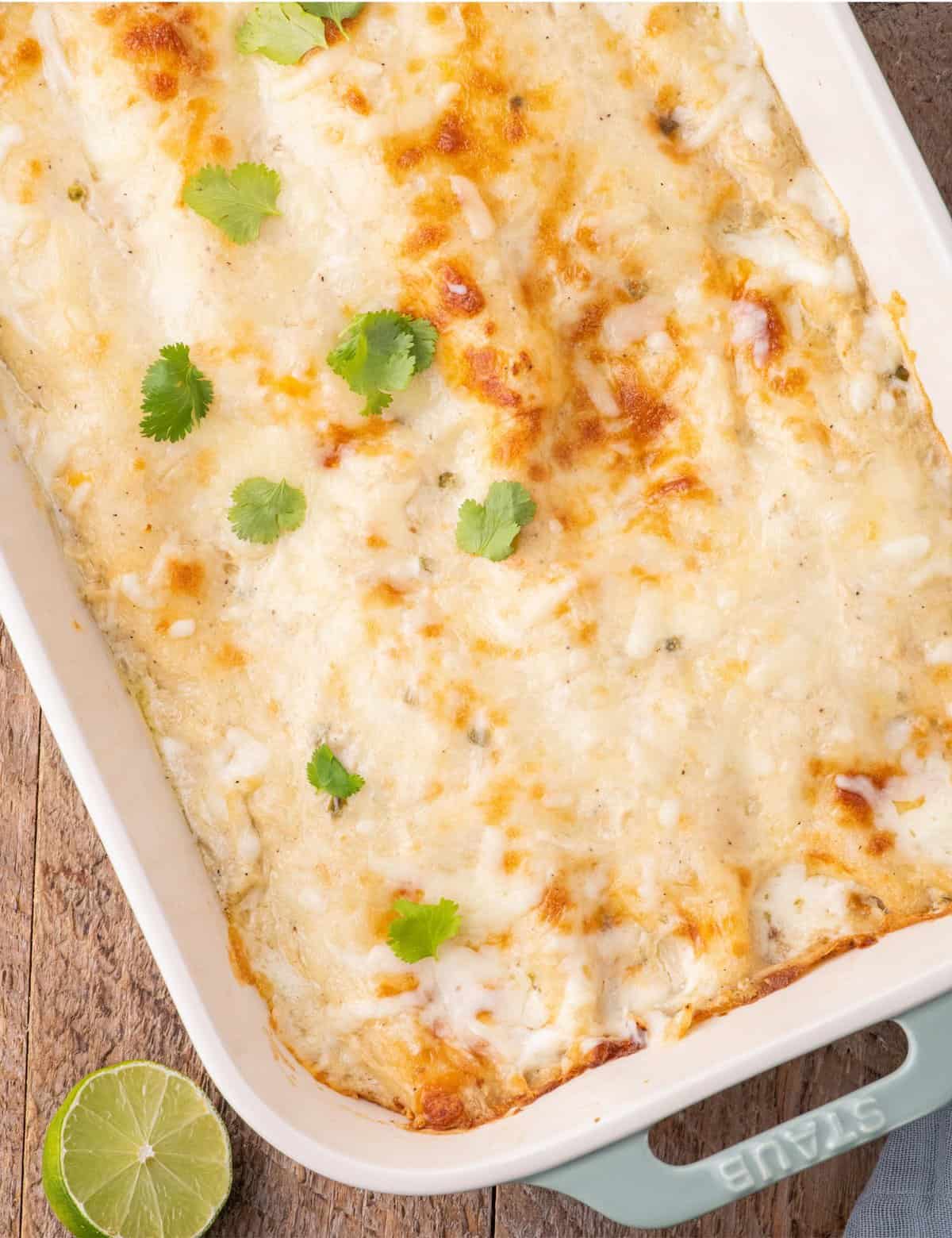 These creamy white chicken enchiladas are made with shredded chicken, smoky salsa verde, piled high with cheese, and smothered in a mouthwatering homemade spicy and creamy sauce, and baked to gooey cheesy perfection!