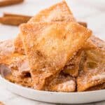 pile of churro chips on a white plate.