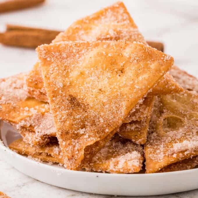 pile of churro chips on a white plate.