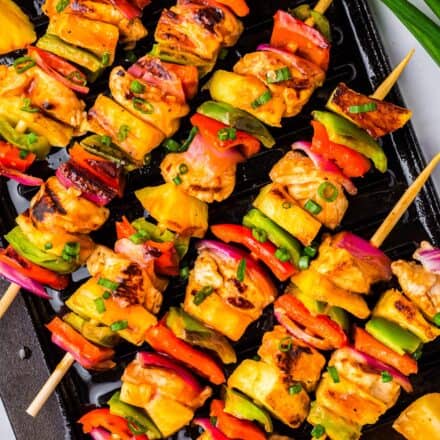 hawaiian chicken skewers on a black grill pan