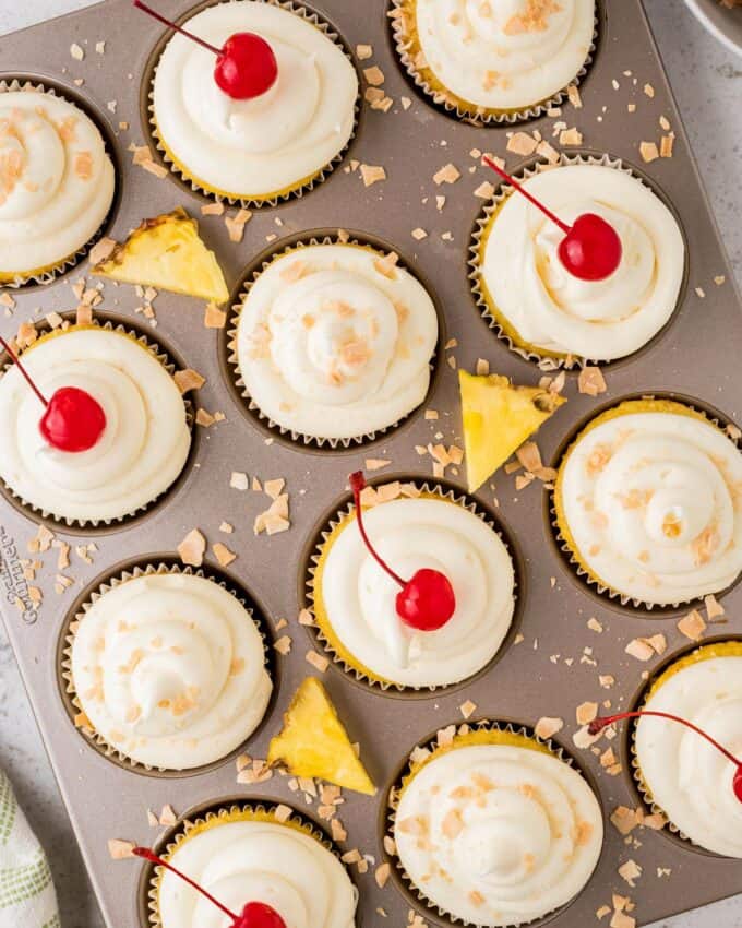 muffin pan full of pineapple and coconut cupcakes